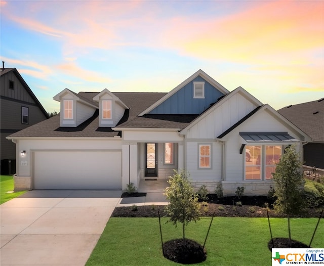 view of front of property featuring a garage and a lawn