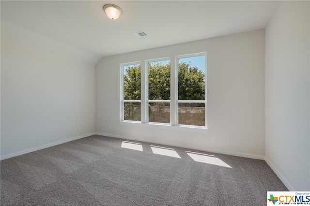 carpeted spare room featuring lofted ceiling