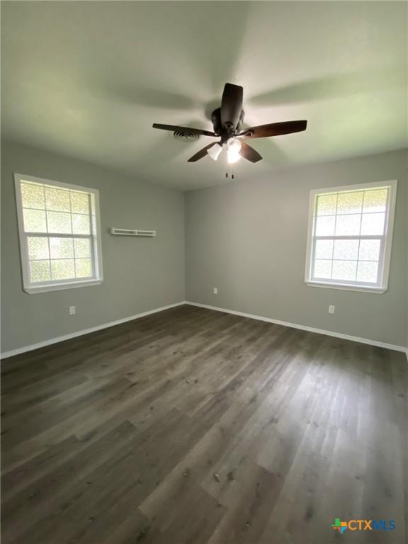 133 Country Acres Dr, Seguin, TX 78155 - empty room featuring plenty of natural light, baseboards, and dark wood-style floors