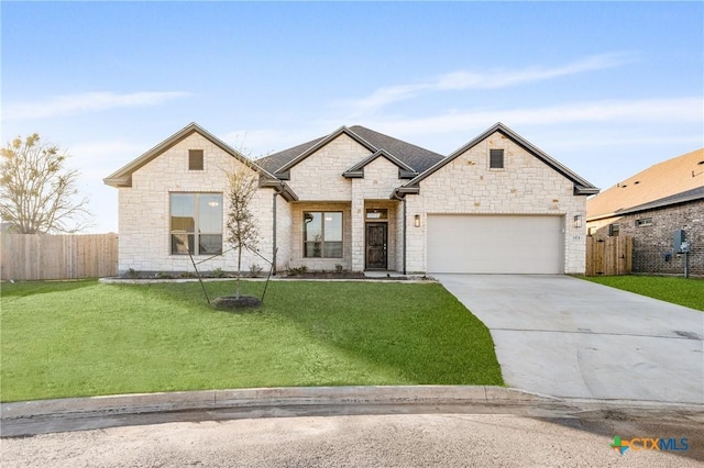 french provincial home with a front yard, concrete driveway, and fence