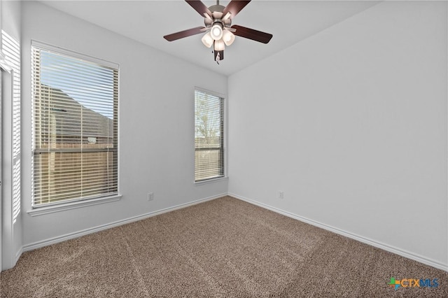 carpeted empty room with ceiling fan and baseboards