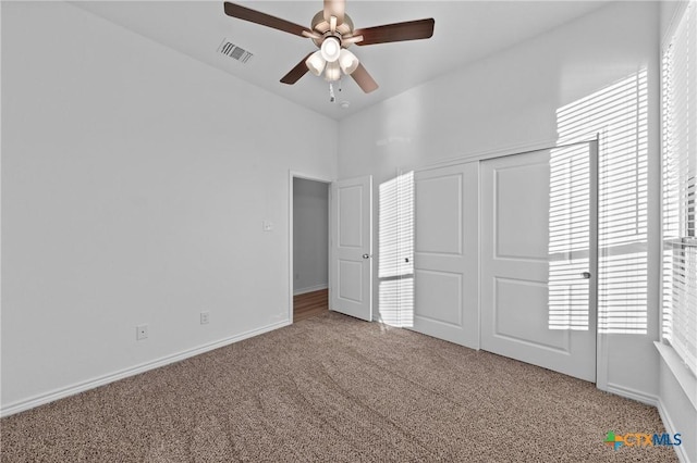 unfurnished bedroom with visible vents, baseboards, a ceiling fan, carpet, and a closet