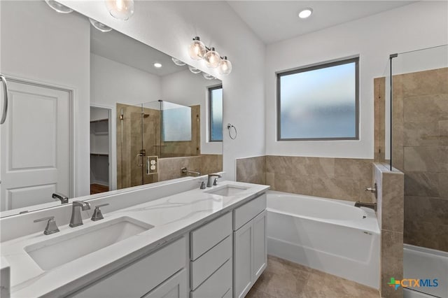 bathroom featuring double vanity, a sink, a shower stall, and a bath