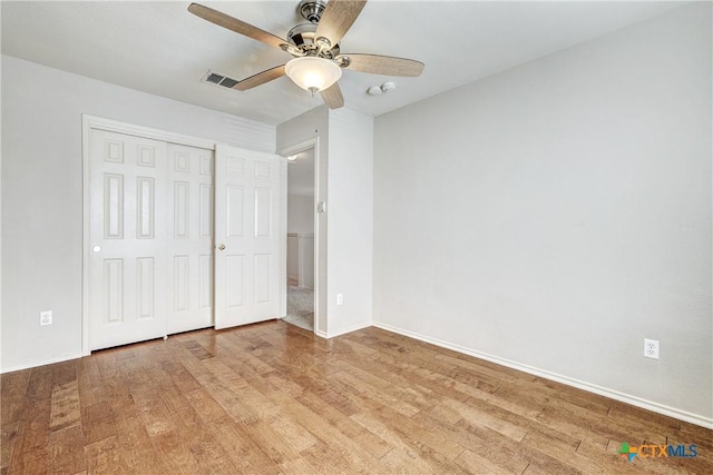 unfurnished bedroom featuring light hardwood / wood-style flooring, a closet, and ceiling fan