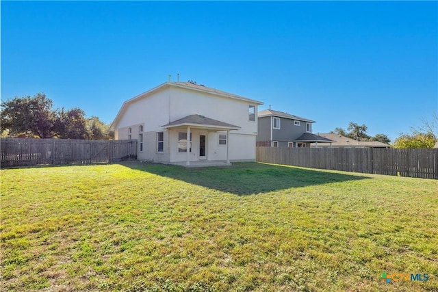 back of house featuring a yard