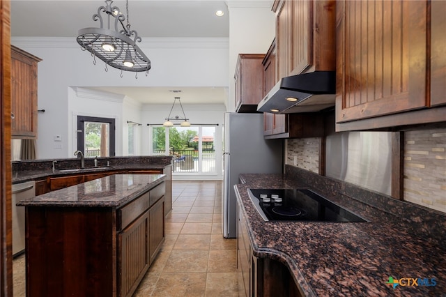 12011 Fm 1150, Luling, TX 78648 - kitchen featuring under cabinet range hood, black electric stovetop, dark stone counters, decorative light fixtures, and a peninsula