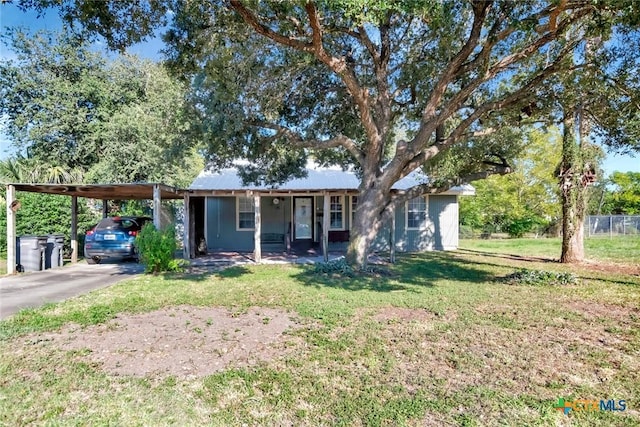 single story home featuring covered porch, a front lawn, aphalt driveway, and a carport