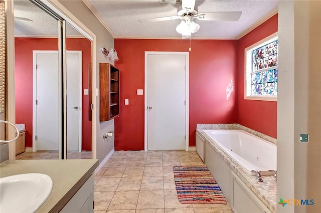 full bathroom featuring a textured ceiling, a tub with jets, and vanity