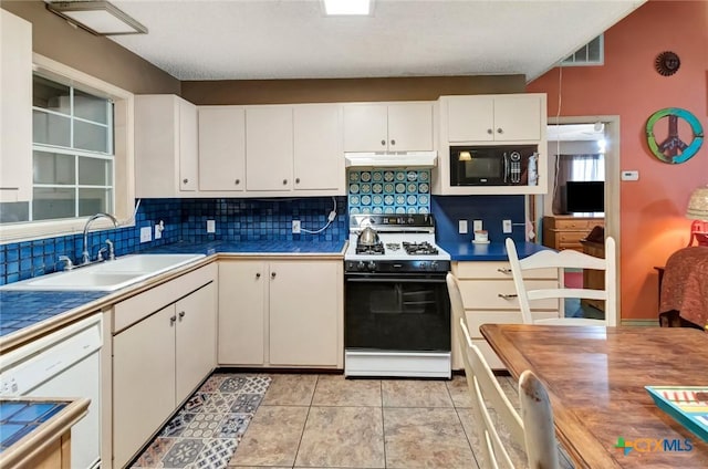 kitchen featuring range with gas stovetop, white dishwasher, a sink, black microwave, and under cabinet range hood