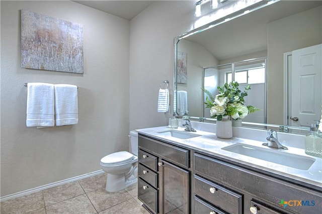 full bathroom with double vanity, tile patterned flooring, a sink, and baseboards