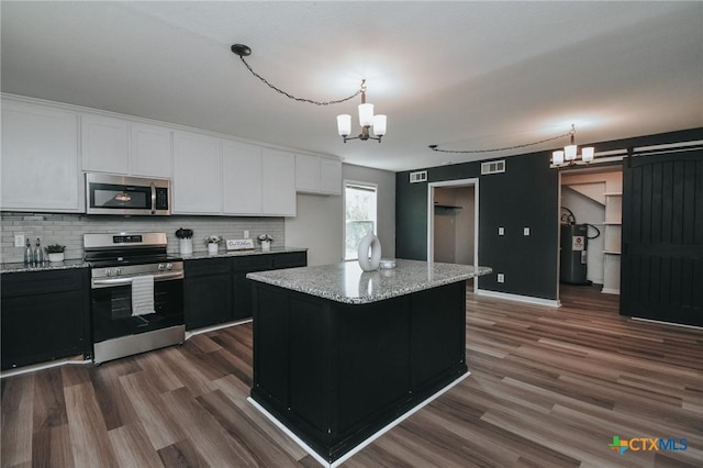 kitchen featuring dark wood-style floors, visible vents, an inviting chandelier, water heater, and appliances with stainless steel finishes