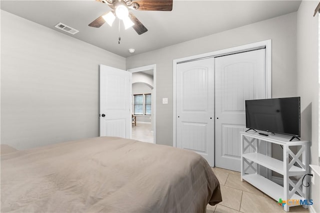 2319 Westview Dr, Canyon Lake, TX 78133 - bedroom with a closet, light tile patterned floors, ceiling fan, arched walkways, and visible vents