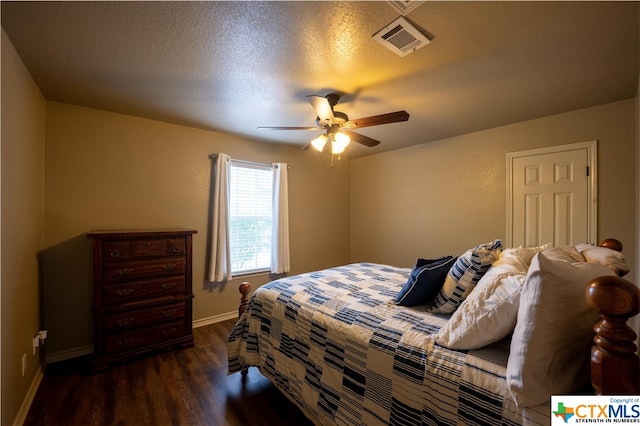 bedroom with a textured ceiling, dark hardwood / wood-style floors, and ceiling fan