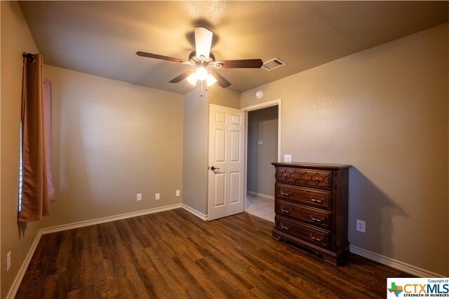 unfurnished bedroom featuring dark wood-type flooring and ceiling fan