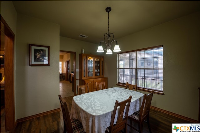 dining space with a notable chandelier and dark hardwood / wood-style floors