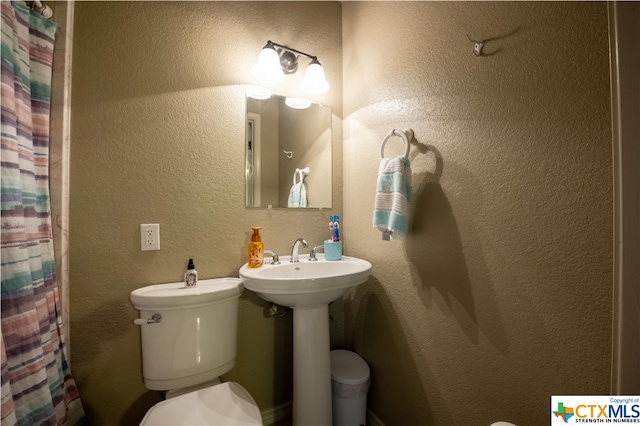 bathroom with toilet and a shower with shower curtain