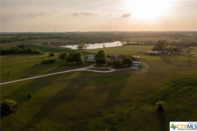 aerial view at dusk with a water view and a rural view