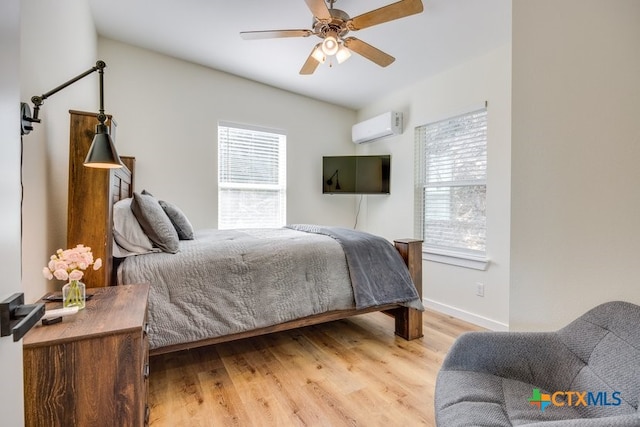 482 Dusty Saddle, Canyon Lake, TX 78133 - bedroom featuring a wall mounted air conditioner, light wood finished floors, and ceiling fan