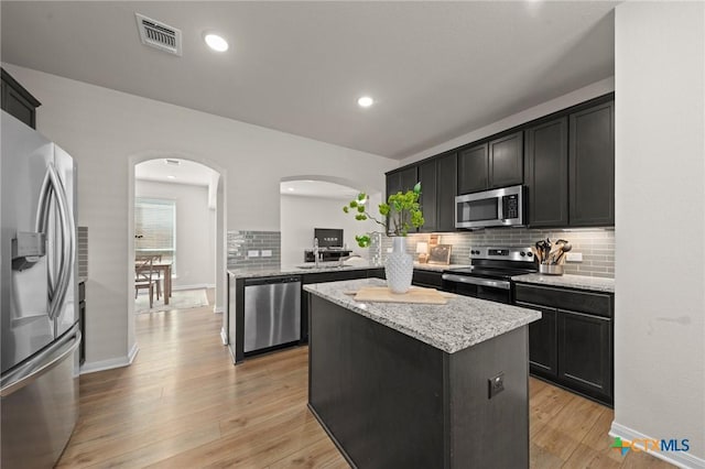 1044 Shelby Dr, Belton, TX 76513 - kitchen featuring visible vents, a kitchen island, stainless steel appliances, arched walkways, and light wood-style floors