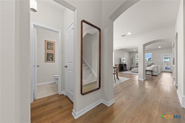 1044 Shelby Dr, Belton, TX 76513 - hall featuring stairway, arched walkways, baseboards, and hardwood / wood-style floors