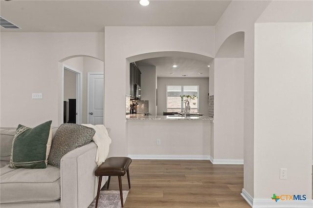 1044 Shelby Dr, Belton, TX 76513 - living room featuring wood finished floors, visible vents, baseboards, recessed lighting, and arched walkways
