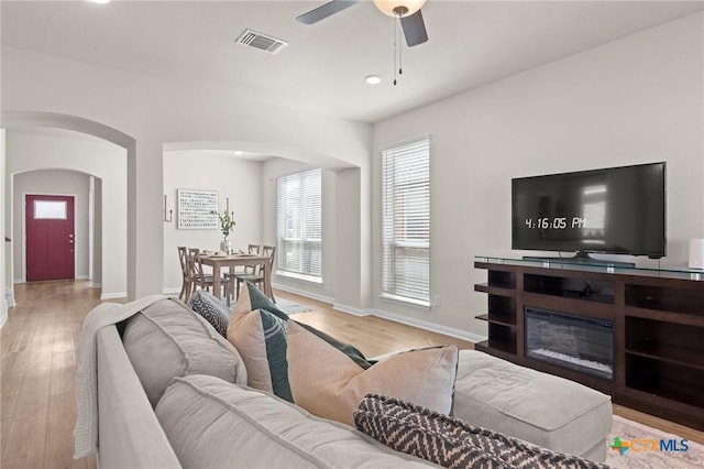 1044 Shelby Dr, Belton, TX 76513 - living area with visible vents, a ceiling fan, wood finished floors, arched walkways, and baseboards