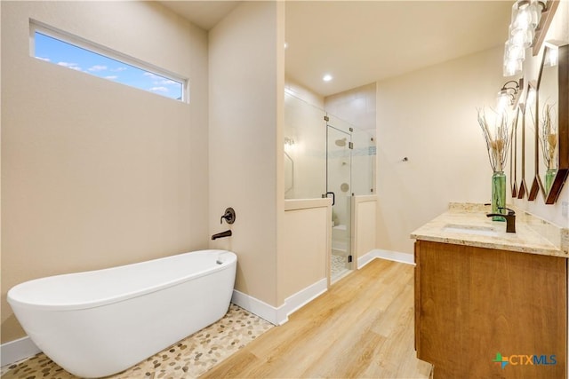 bathroom with vanity, wood-type flooring, and shower with separate bathtub