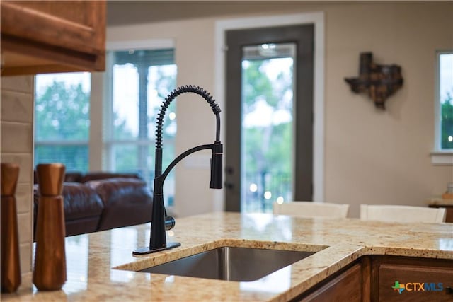 interior details featuring light stone countertops and sink