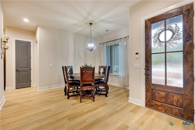 dining area featuring light hardwood / wood-style floors and a chandelier