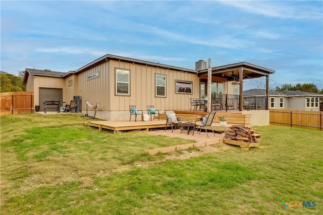 rear view of house with a lawn and a wooden deck