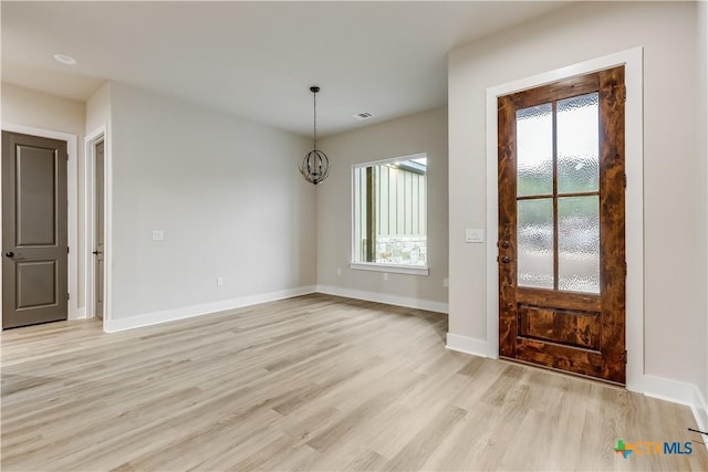 entrance foyer featuring a notable chandelier and light hardwood / wood-style flooring