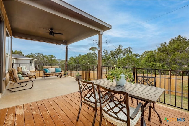 wooden deck with an outdoor living space and ceiling fan