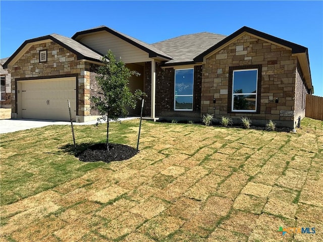 view of front of home featuring an attached garage, driveway, and stone siding