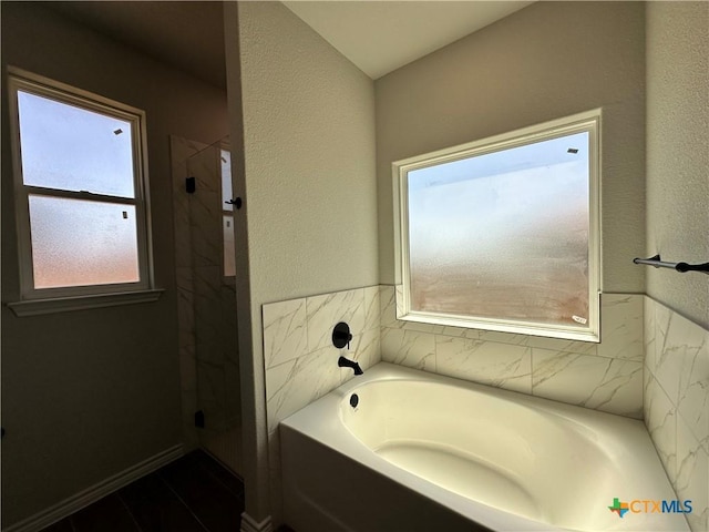full bath with a bath and a shower
