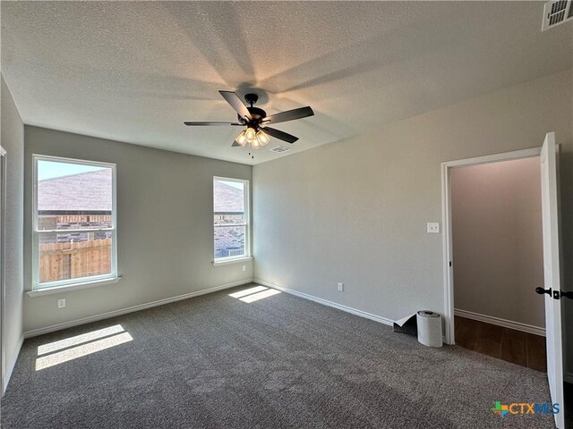 empty room featuring carpet, a ceiling fan, baseboards, and a textured ceiling