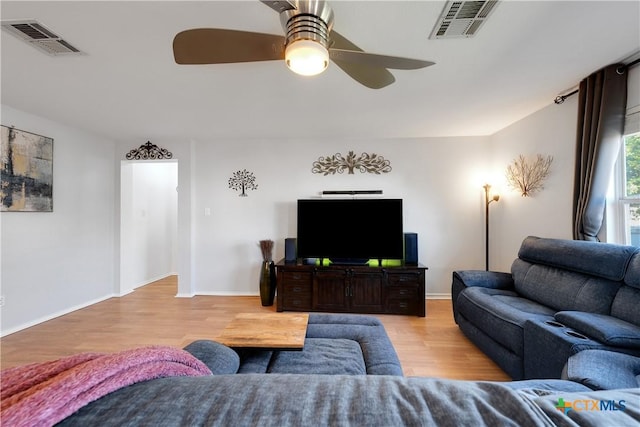 living room featuring visible vents, ceiling fan, and wood finished floors