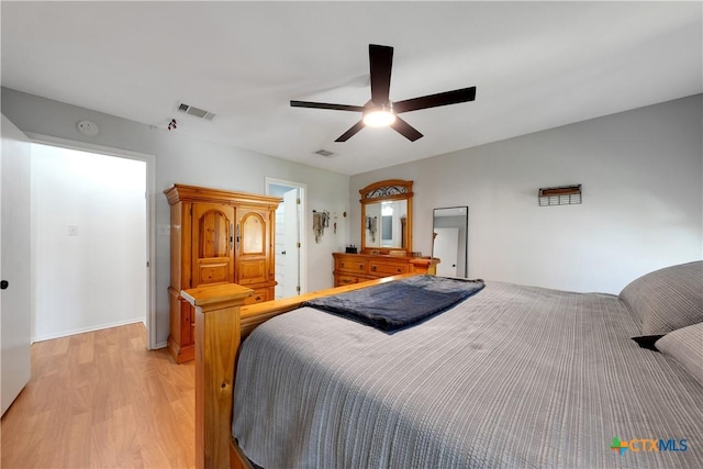 bedroom featuring visible vents, light wood finished floors, and a ceiling fan