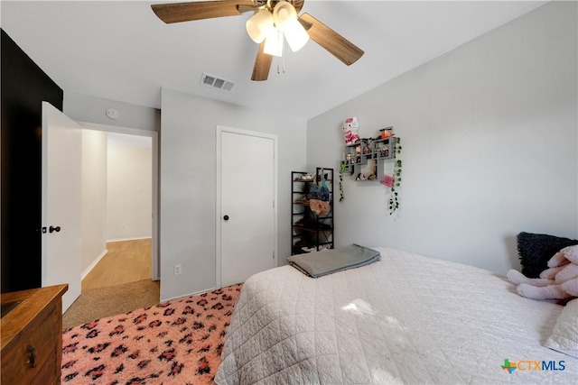 carpeted bedroom with visible vents and ceiling fan
