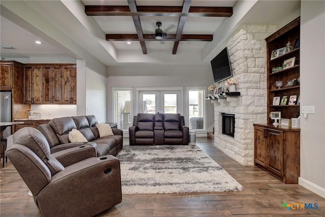 living room featuring beamed ceiling, coffered ceiling, dark wood-style floors, french doors, and a fireplace