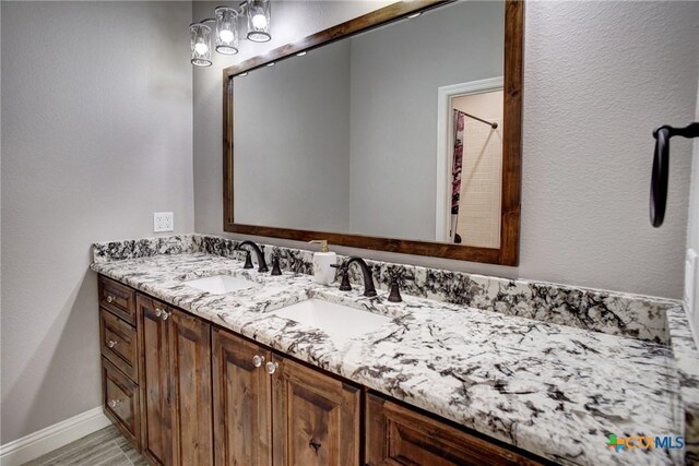 full bath featuring baseboards and vanity