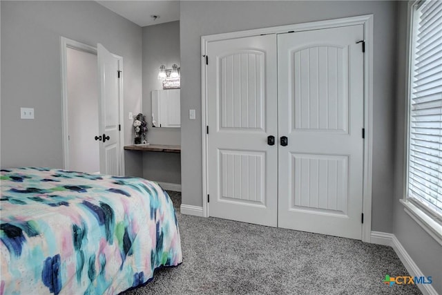 carpeted bedroom featuring a closet and baseboards