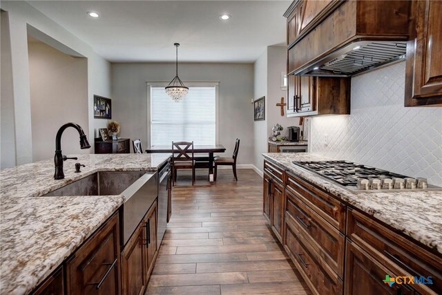 kitchen featuring custom range hood, light stone counters, tasteful backsplash, stainless steel appliances, and dark wood-style flooring