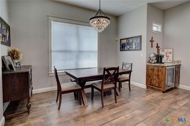 dining room with wood finished floors, baseboards, and a chandelier