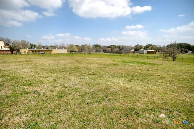 view of yard with a rural view and fence