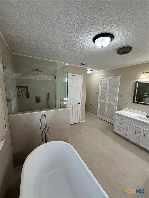 6601 Wells Fargo Rd, Killeen, TX 76542 - full bath with a textured ceiling, vanity, a freestanding bath, and a walk in shower