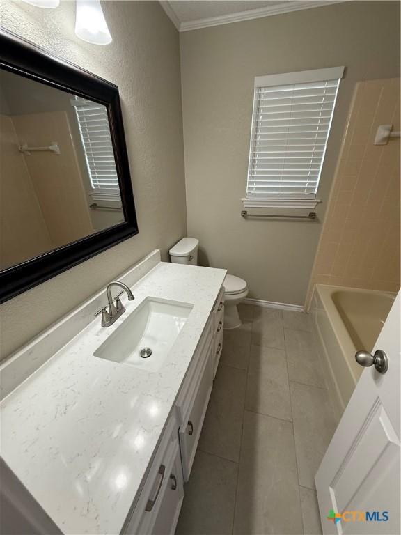 6601 Wells Fargo Rd, Killeen, TX 76542 - full bathroom featuring crown molding, vanity, toilet, tile patterned floors, and baseboards