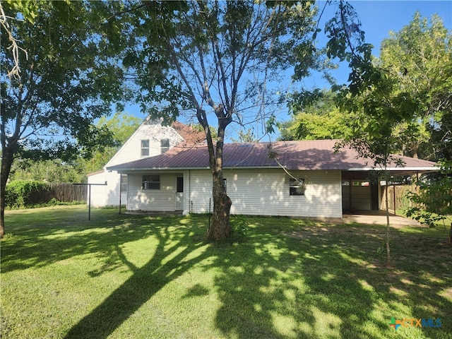 rear view of property with a garage and a lawn