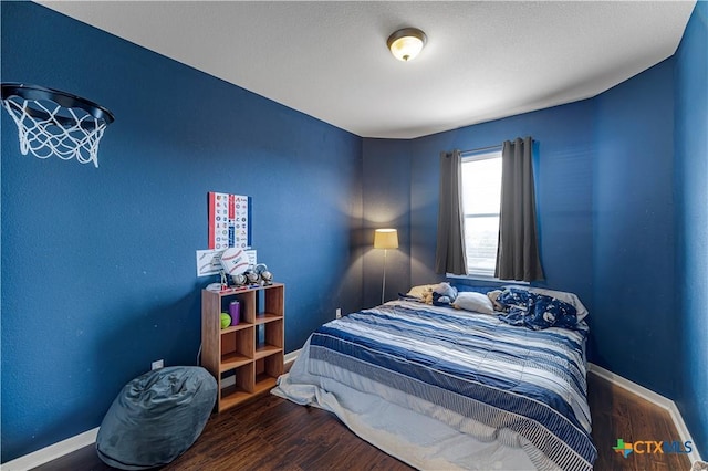 bedroom with baseboards and wood finished floors