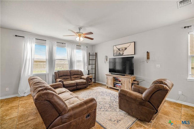 living area with visible vents, a ceiling fan, and baseboards