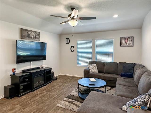 living room featuring ceiling fan, a textured ceiling, and hardwood / wood-style flooring